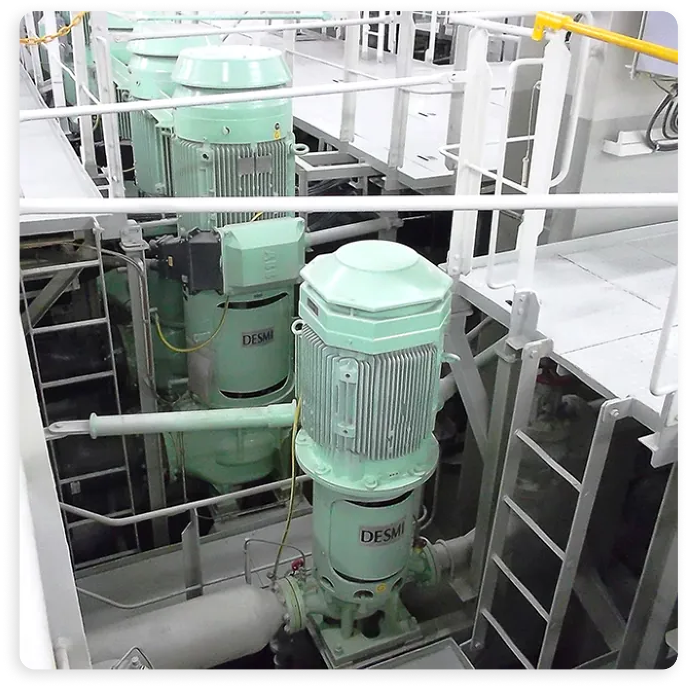 The image depicts an industrial facility featuring several pumps.